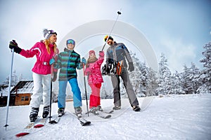 Winter time and skiing - family with ski and snowboard on ski ho